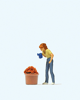 Femme avec arrosoir arrosant un gros pot de fleur